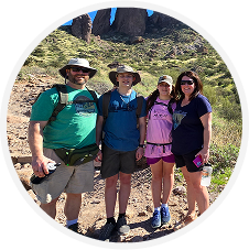 Four people hiking in a desert landscape.